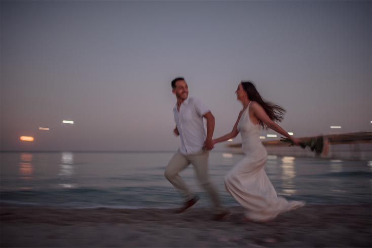 Couple running hand in hand at sunset, photographed by a Fort Lauderdale beach photographer