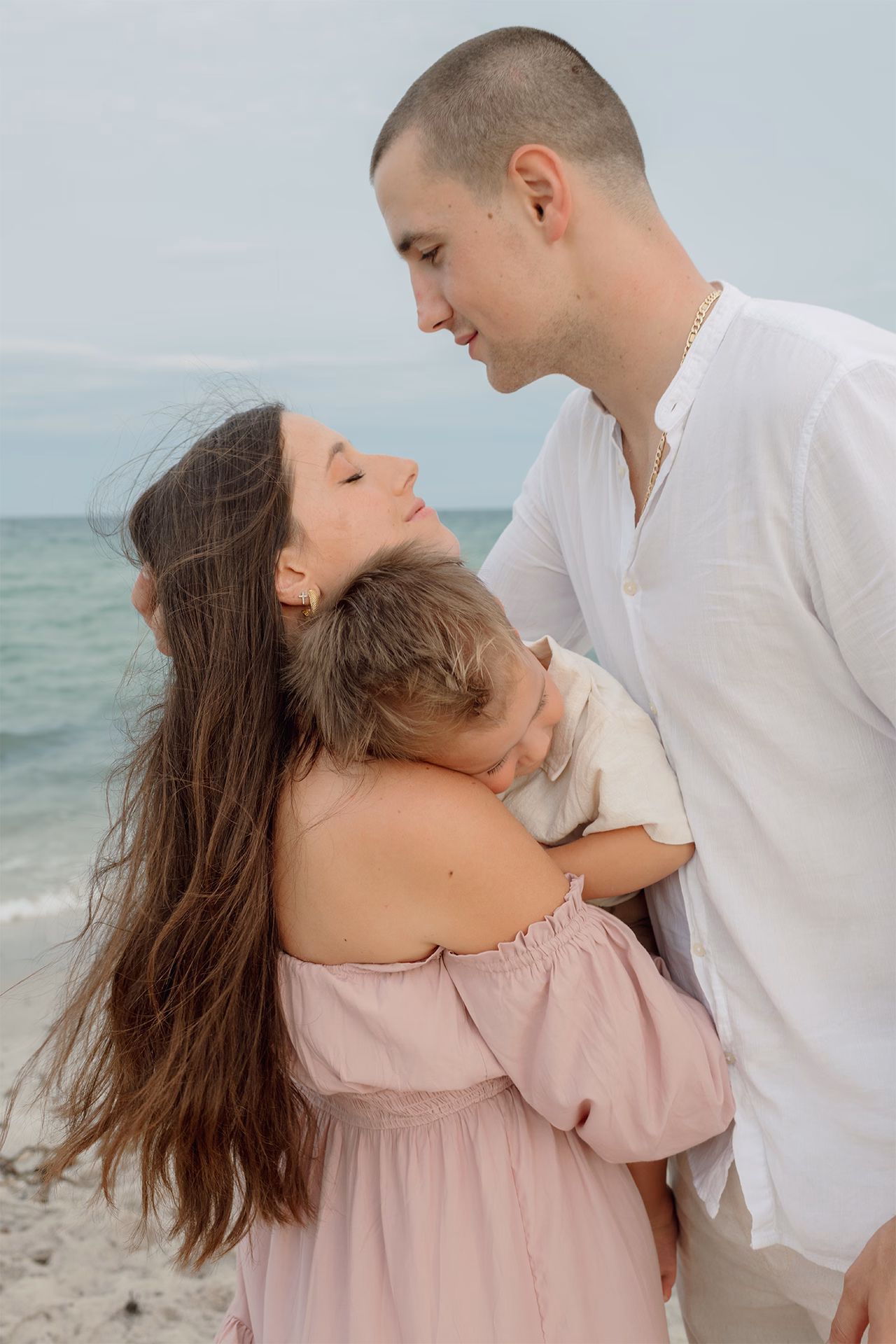 Close up of a sweet family of three by the beach