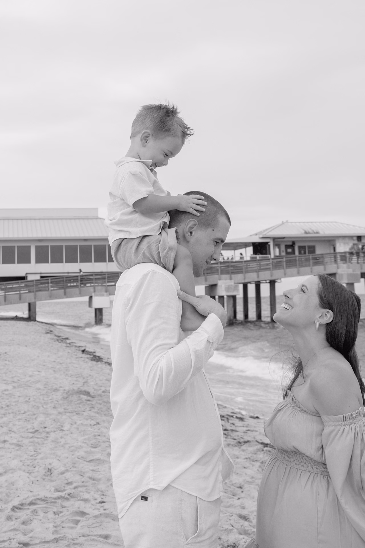 Family of three smiling at each other