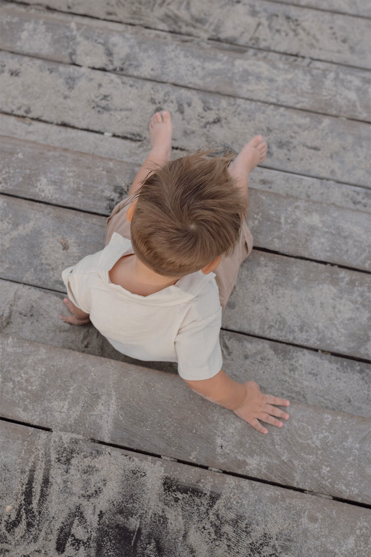 Toddler sitting down on pier