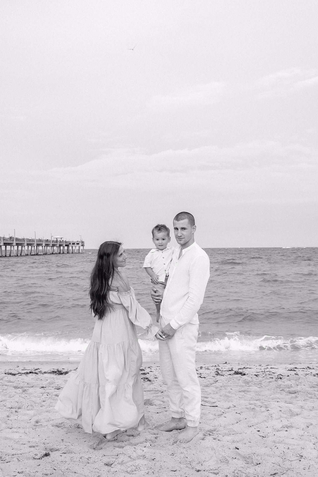 Family of three with beach in the background