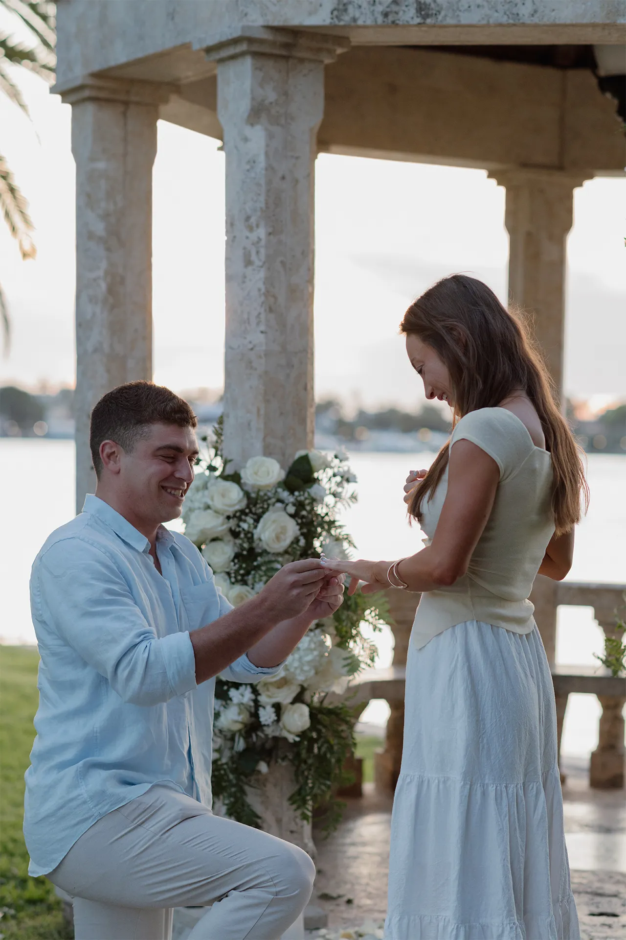 Groom-to-be proposing at floral gazebo in Palm Beach.