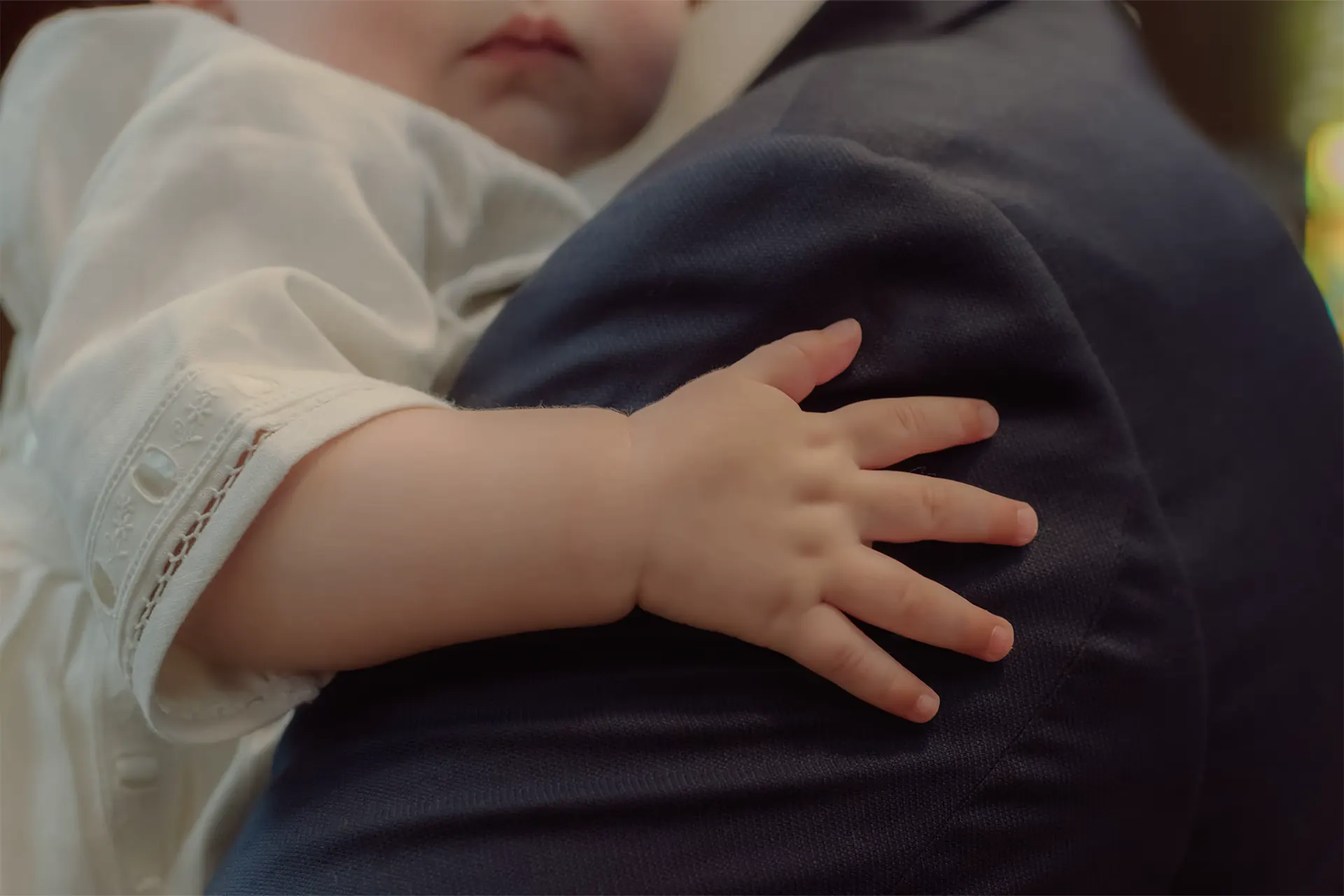 Loving portrait of a baby boy with his father during the baptism celebration