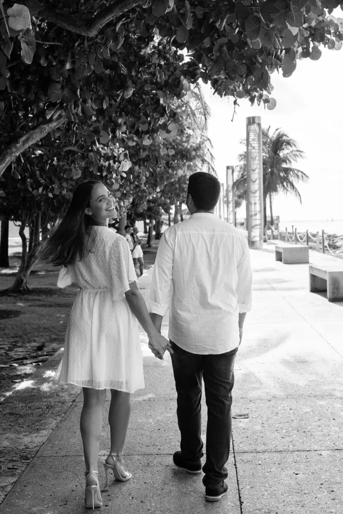 Black and white portrait of couple walking down South Pointe Park