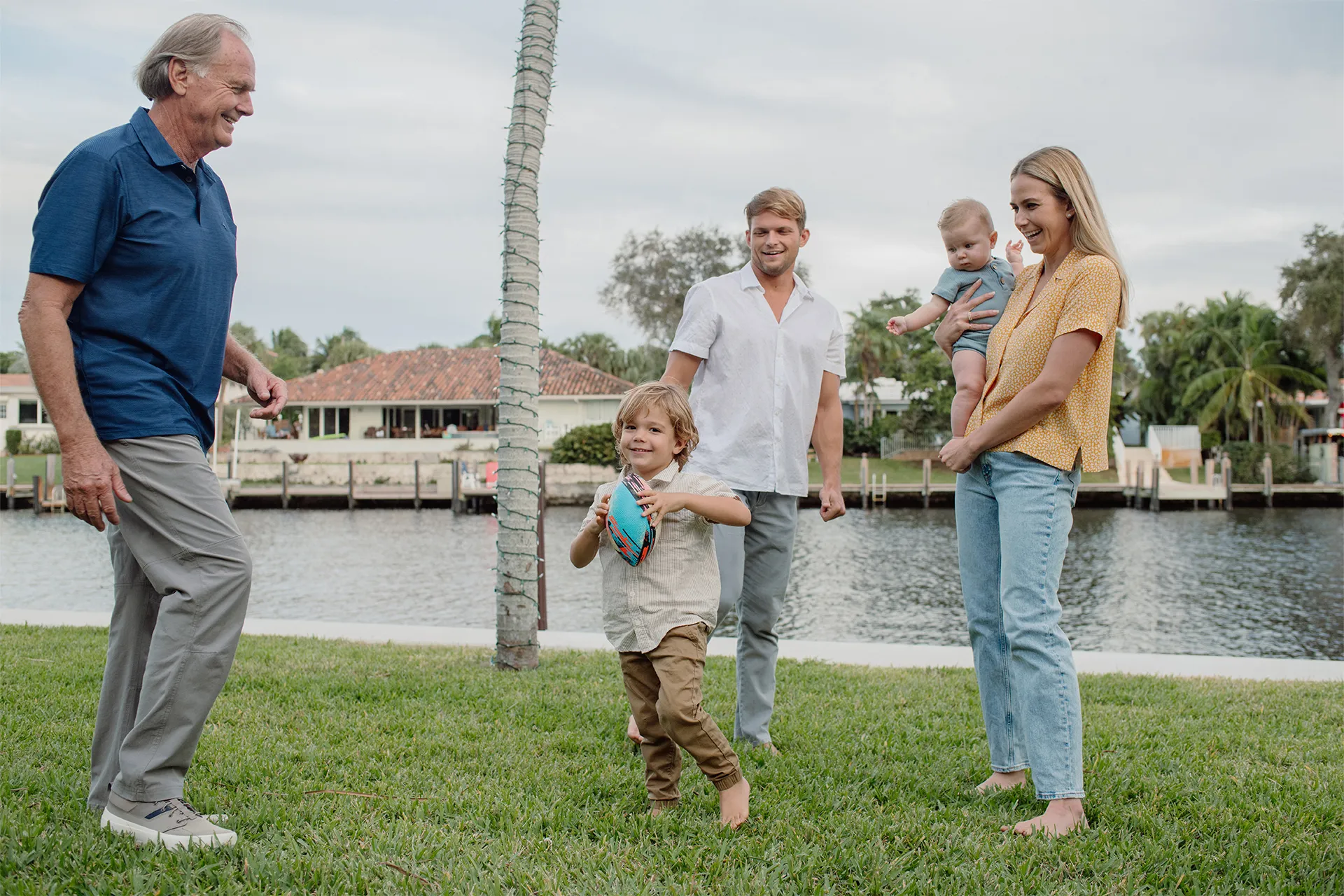 Candid family playing football during a Fort Lauderdale photo session.