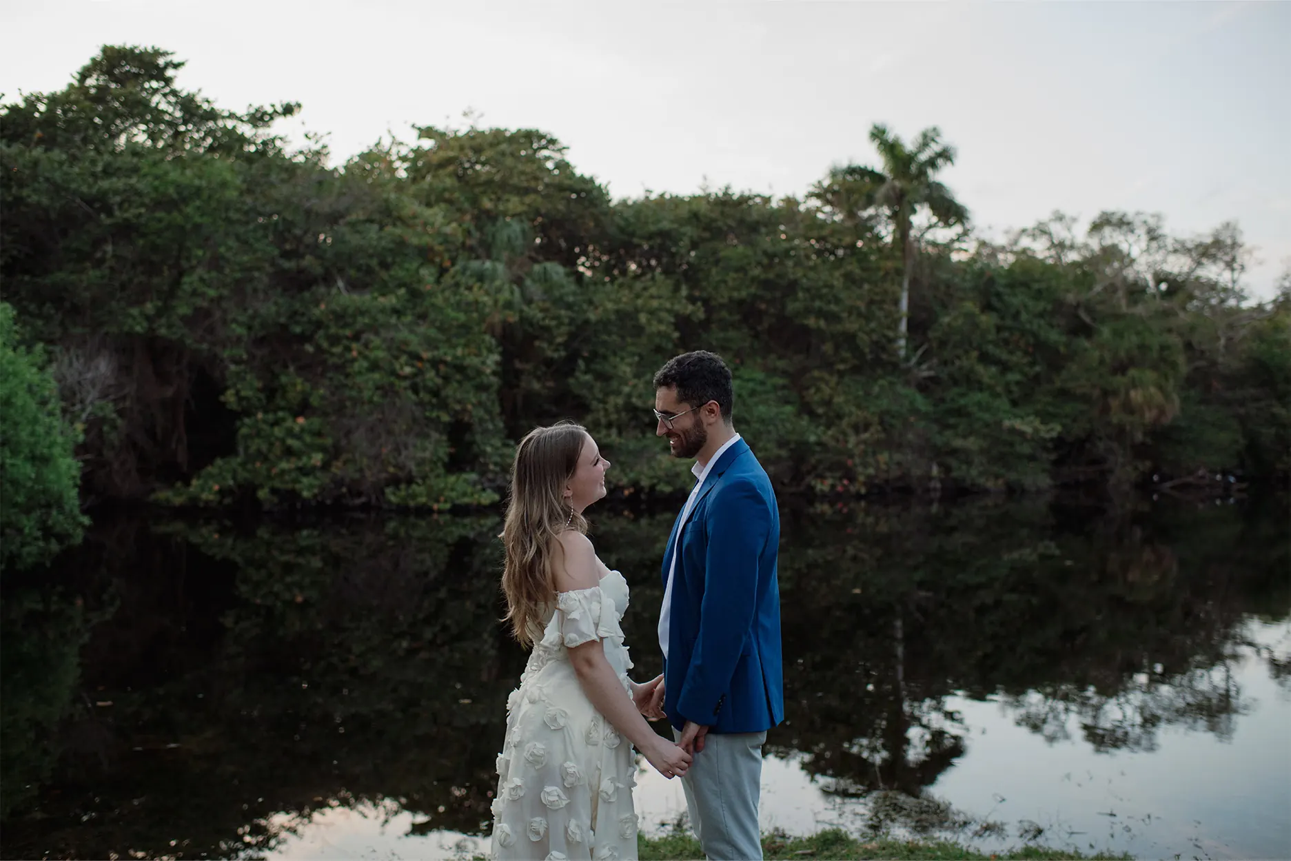 Couple holding hands in front of the lake at Hugh Taylor Birch State Park
