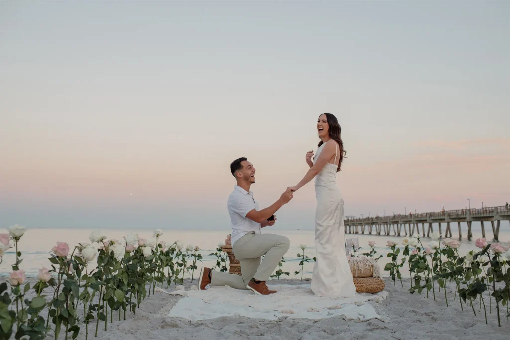 The defining moment: he kneels on the sand to propose at sunset in Dania Beach