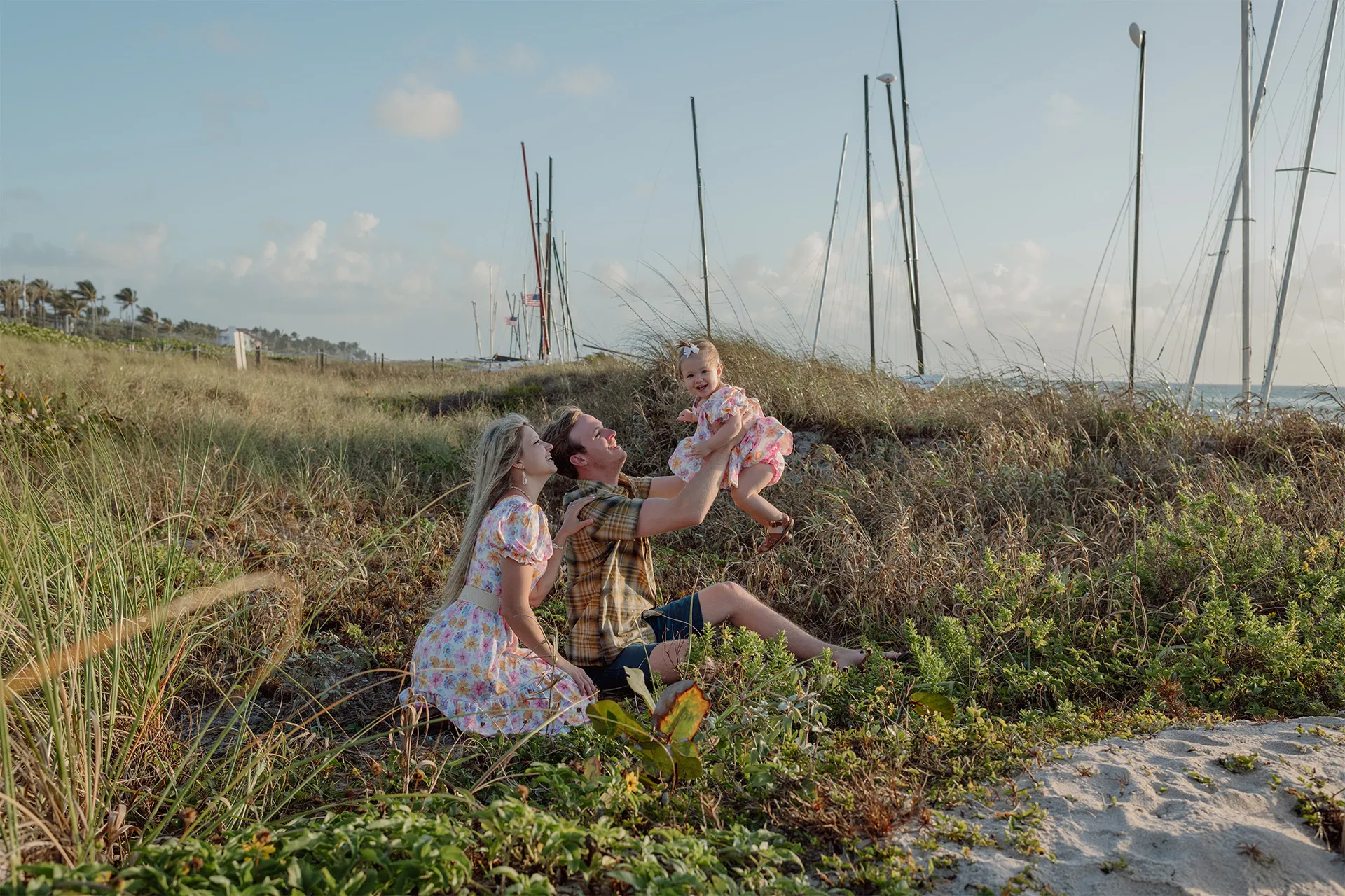 Relaxed family of three sitting down for a professional photo shoot in Delray Beach.