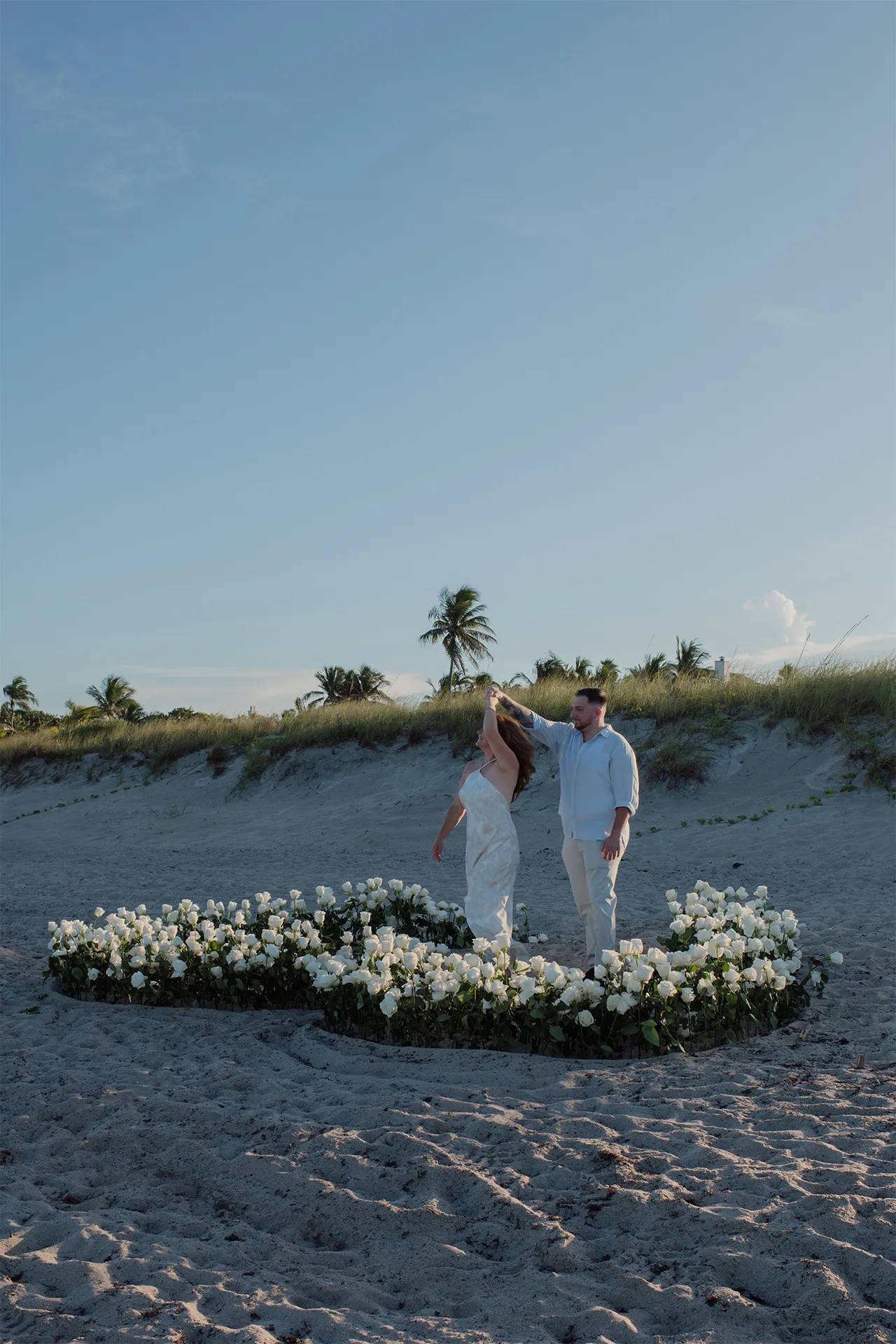 Couple enjoying a private dance on the sand after their marriage proposal
