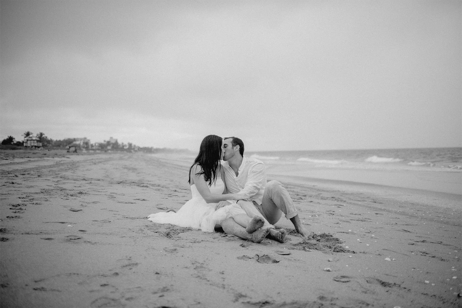 Relaxed couple sitting down in the sand enjoying the rainy sunrise in Florida