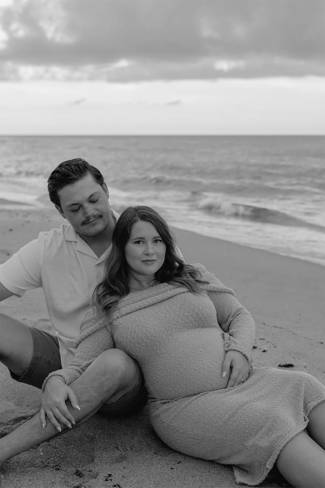 Intimate black and white maternity portrait at the water's edge