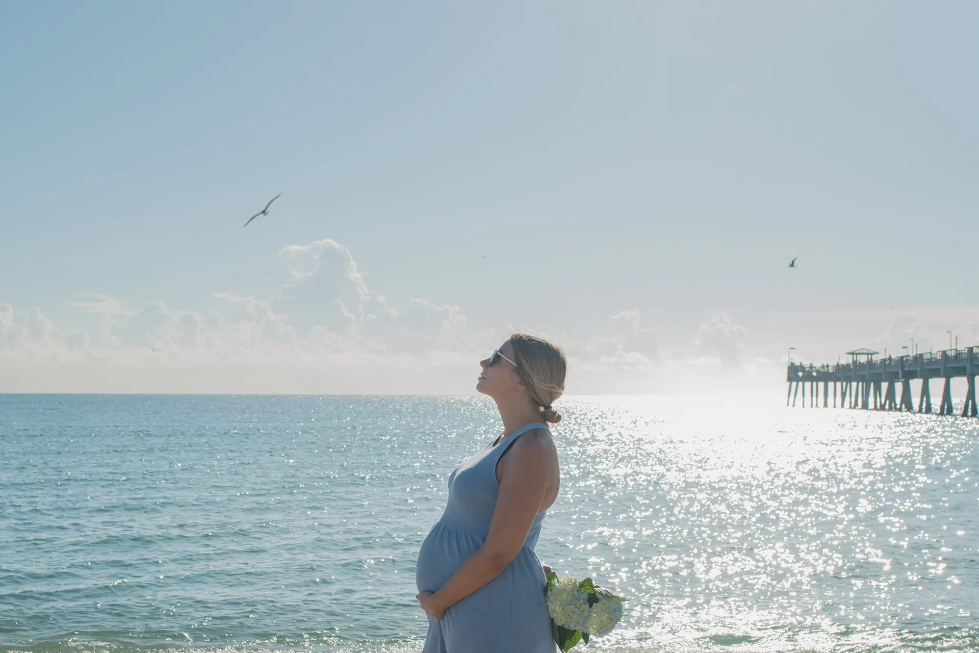 Maternity portraits with the iconic Dania Beach pier and waves in the background