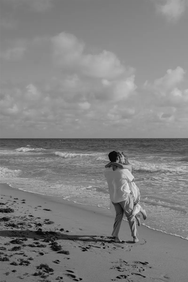 Black and white image of a groom holding his fiance during their Fort Lauderdale proposal session